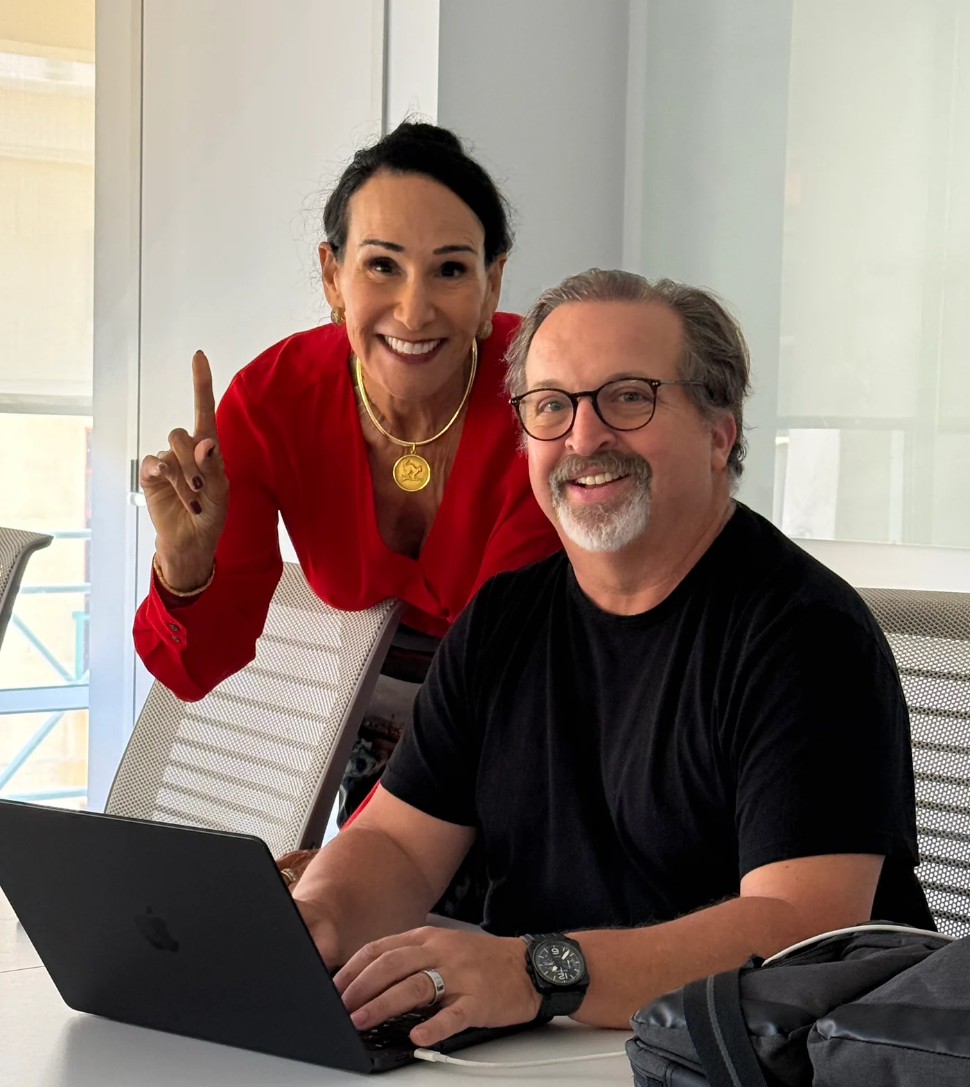 Two people smiling together in an office.